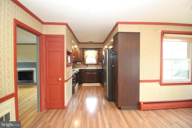 a view of a hallway with wooden floor and a living room