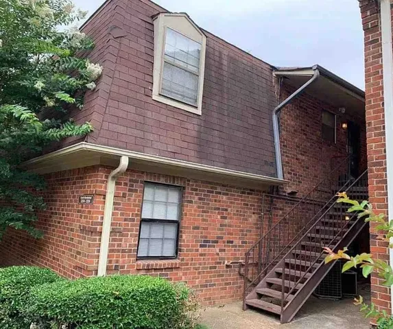 a front view of a house with plants