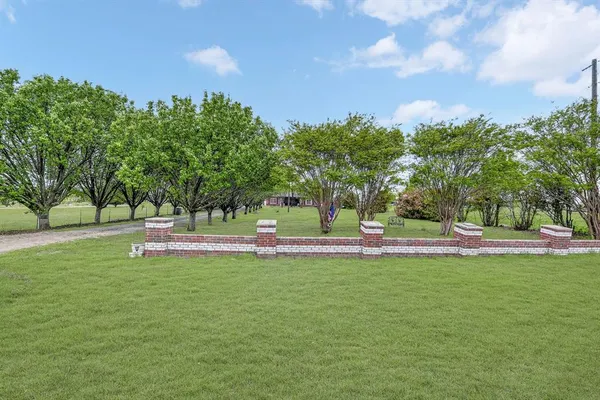 a view of a fountain in front of a house with a big yard
