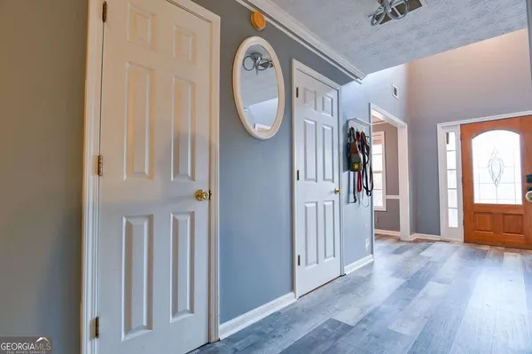 a view of a hallway with entryway wooden floor and front door
