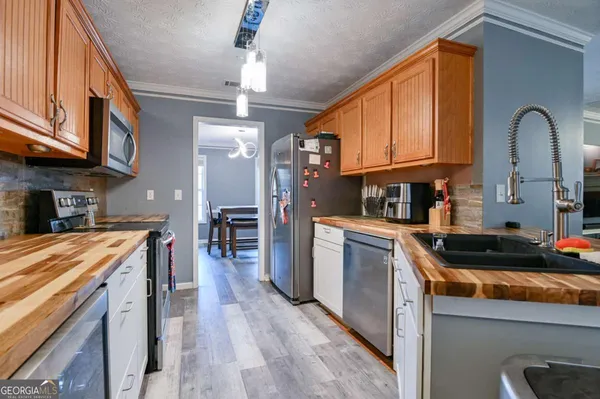 a kitchen with stainless steel appliances granite countertop a stove a sink and a refrigerator