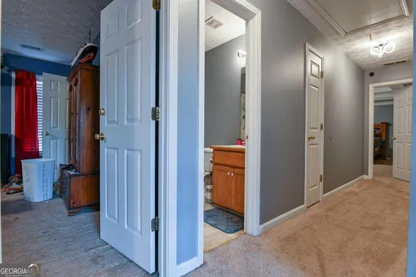 a view of a hallway with closet and a bathroom