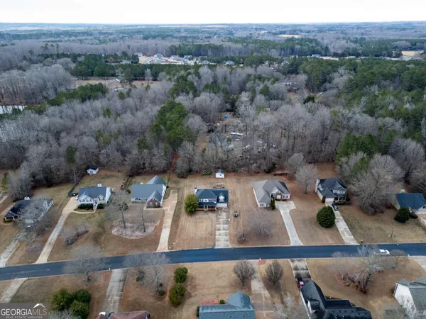 a view of a white house with a big yard and large trees