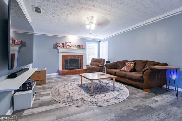 a living room with furniture a fireplace and a flat screen tv