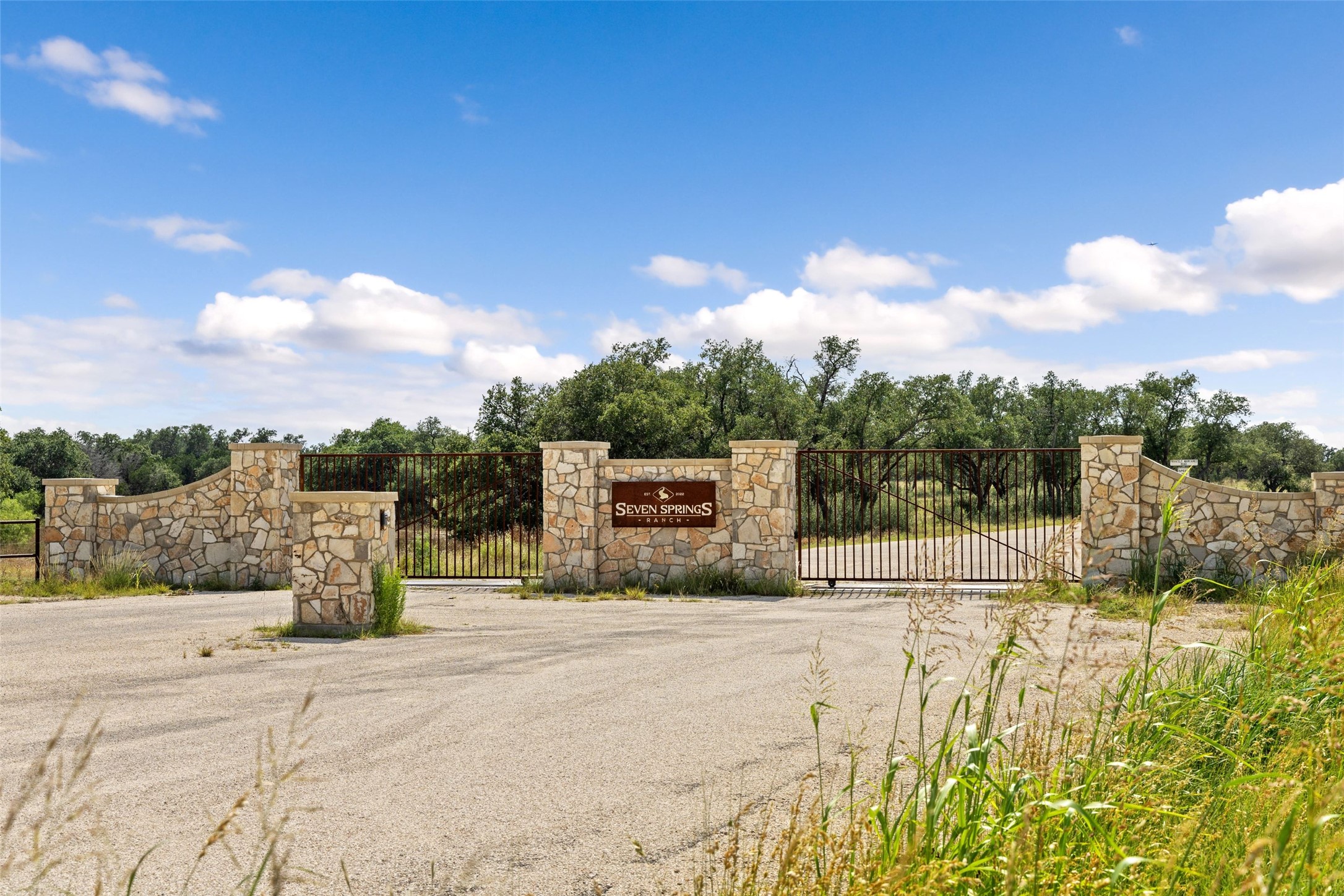 2915 Spring Crossing Junction, TX 76849 - Photo 2 of 31 Secure community entrance with an elegant stone wall and stately iron gate.