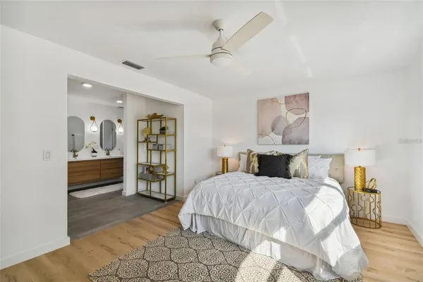 a bedroom with a large bed and a chandelier
