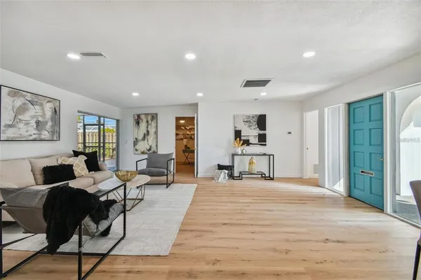a living room with furniture and a wooden floor
