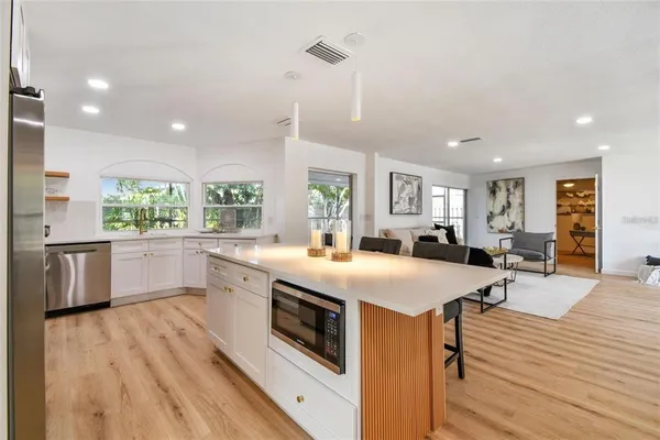 a large kitchen with stainless steel appliances a lot of counter space and a wooden floor