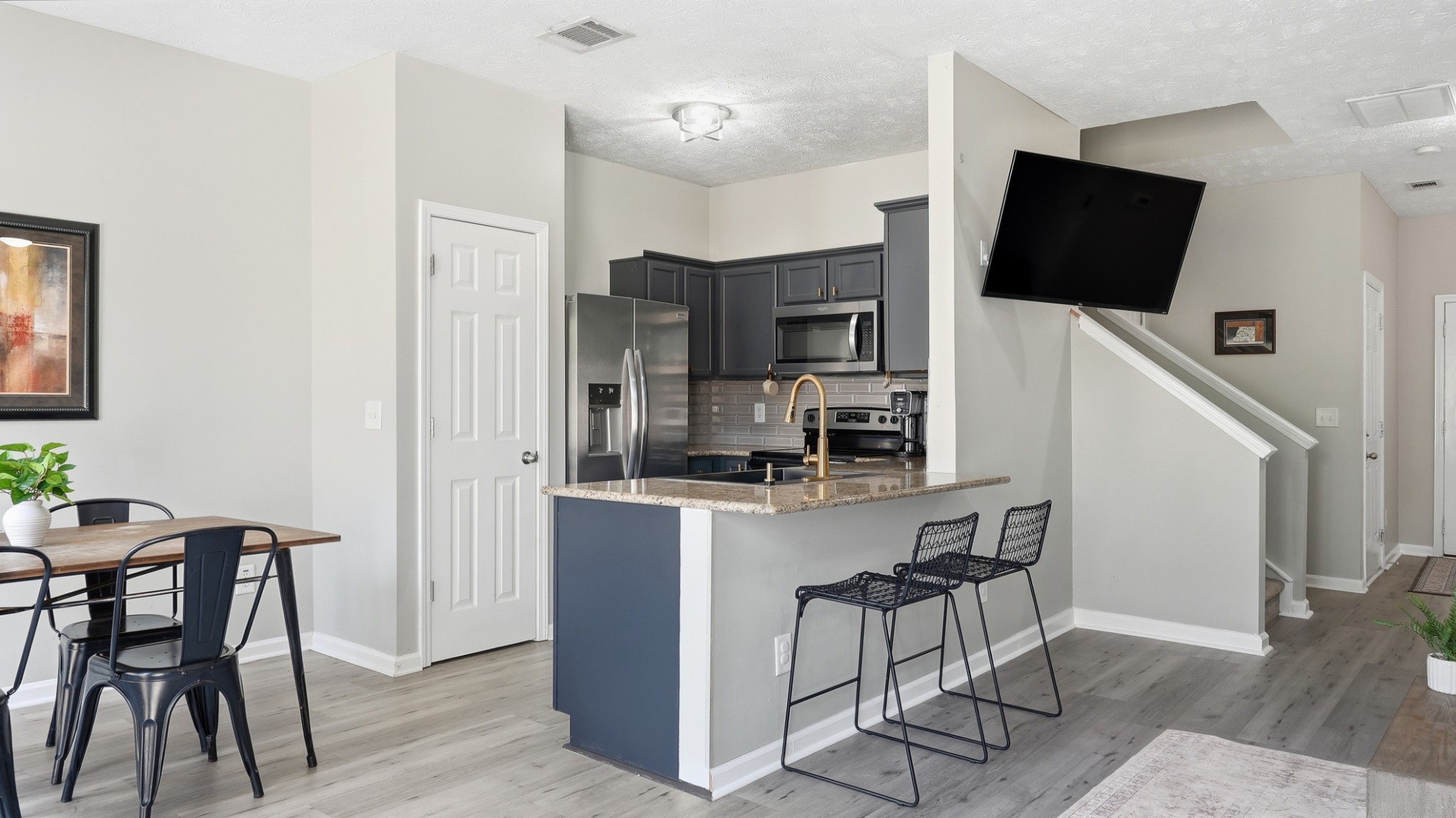 8215 Rossi Road Brentwood, TN 37027 - Photo 7 of 22 a kitchen with stainless steel appliances a microwave a stove a refrigerator a table and chairs