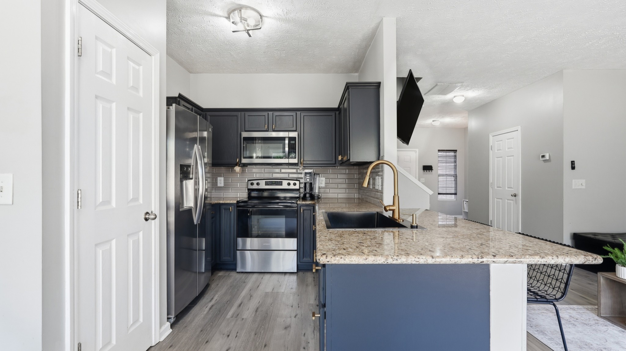 8215 Rossi Road Brentwood, TN 37027 - Photo 8 of 22 a kitchen with kitchen island granite countertop a stove refrigerator and microwave