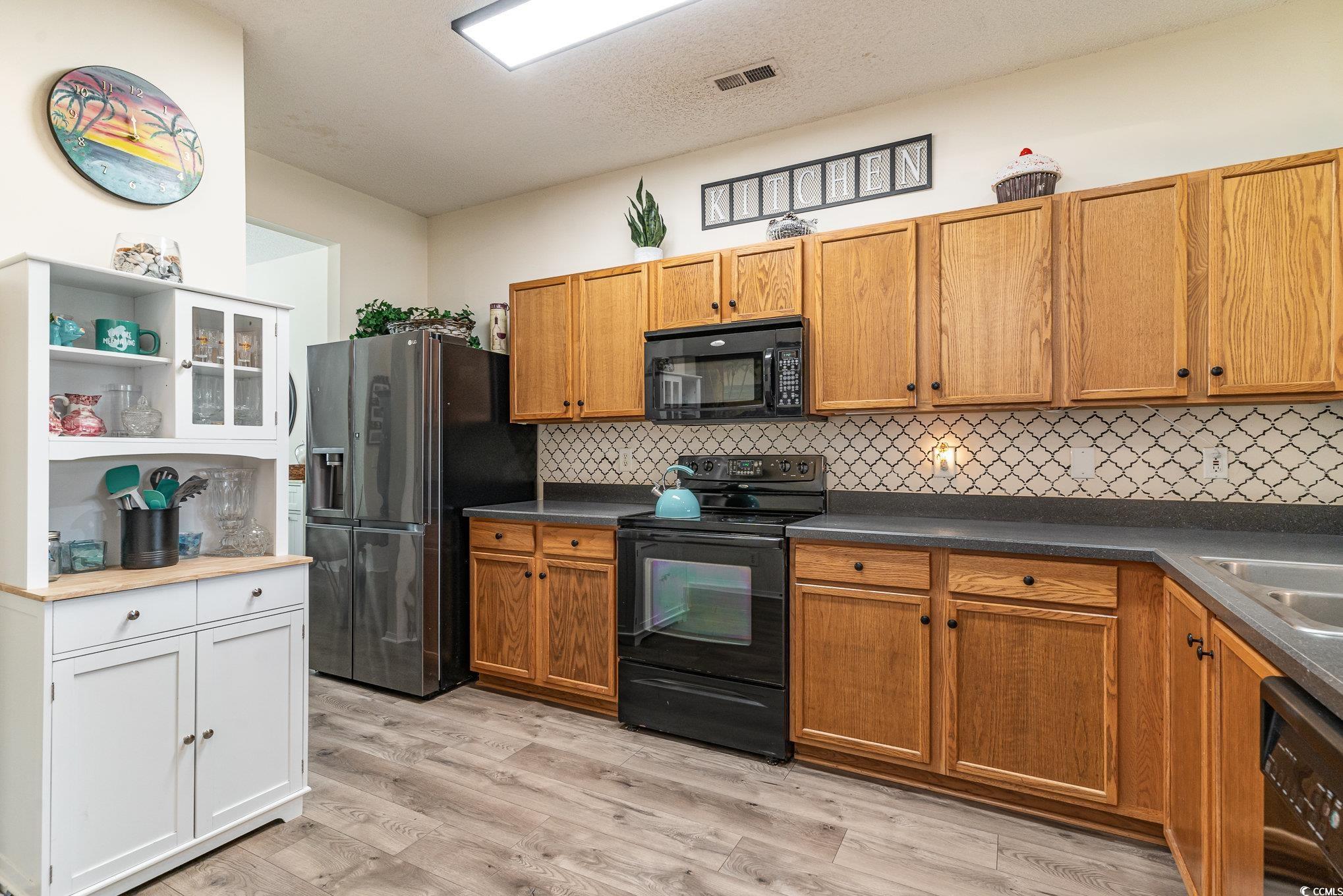 316 Kiskadee Loop, Unit 9E Conway, SC 29526 - Photo 11 of 40 Kitchen with black appliances, sink, backsplash, a