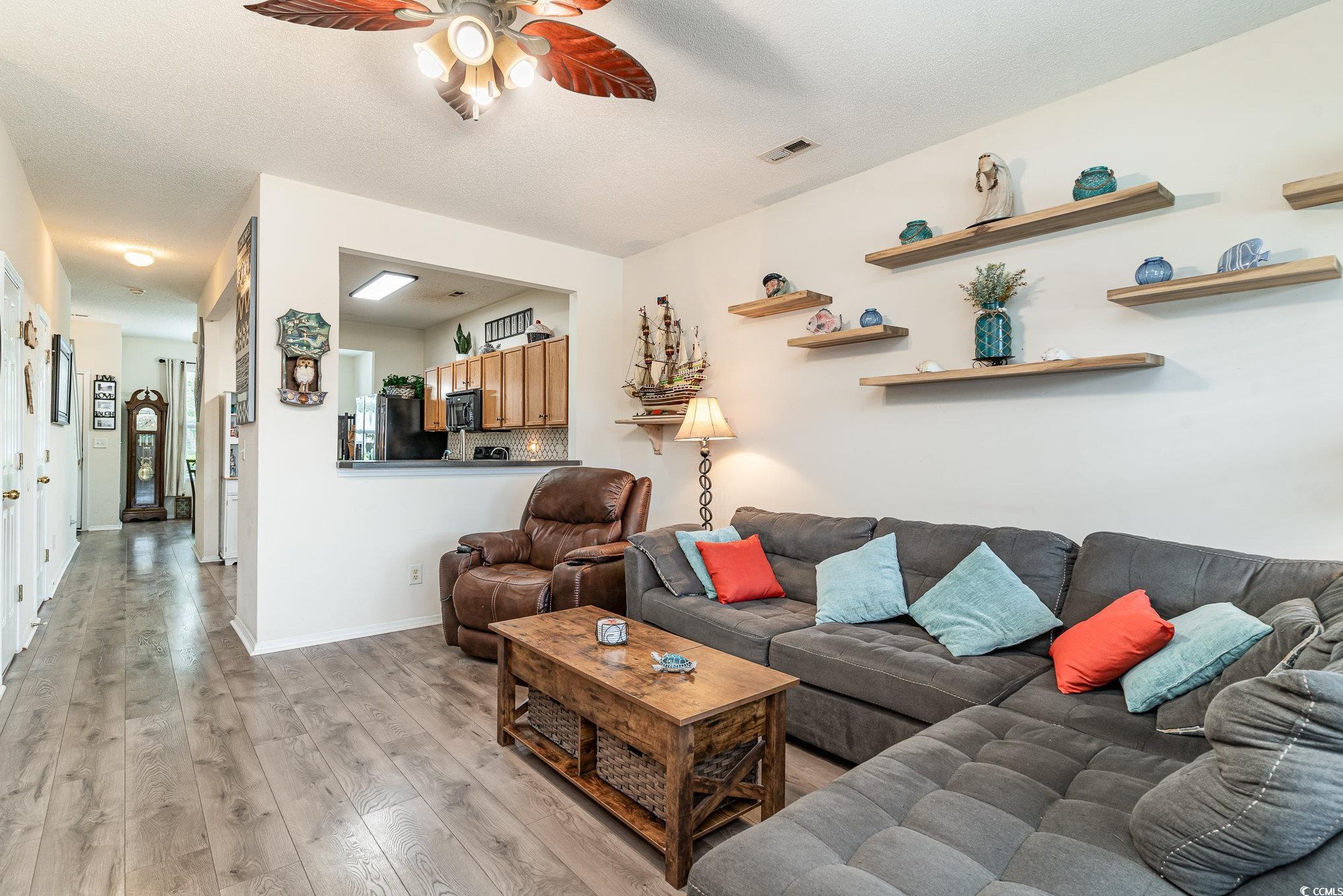 316 Kiskadee Loop, Unit 9E Conway, SC 29526 - Photo 13 of 40 Living room featuring ceiling fan and light hardwo