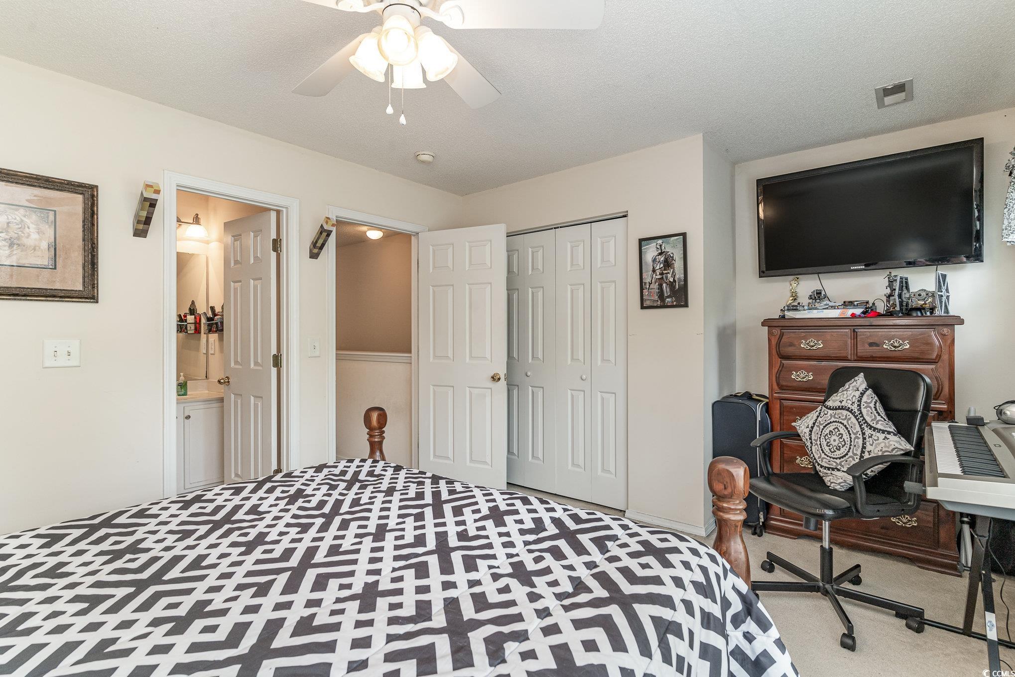 316 Kiskadee Loop, Unit 9E Conway, SC 29526 - Photo 25 of 40 Bedroom with a textured ceiling, ceiling fan, a cl