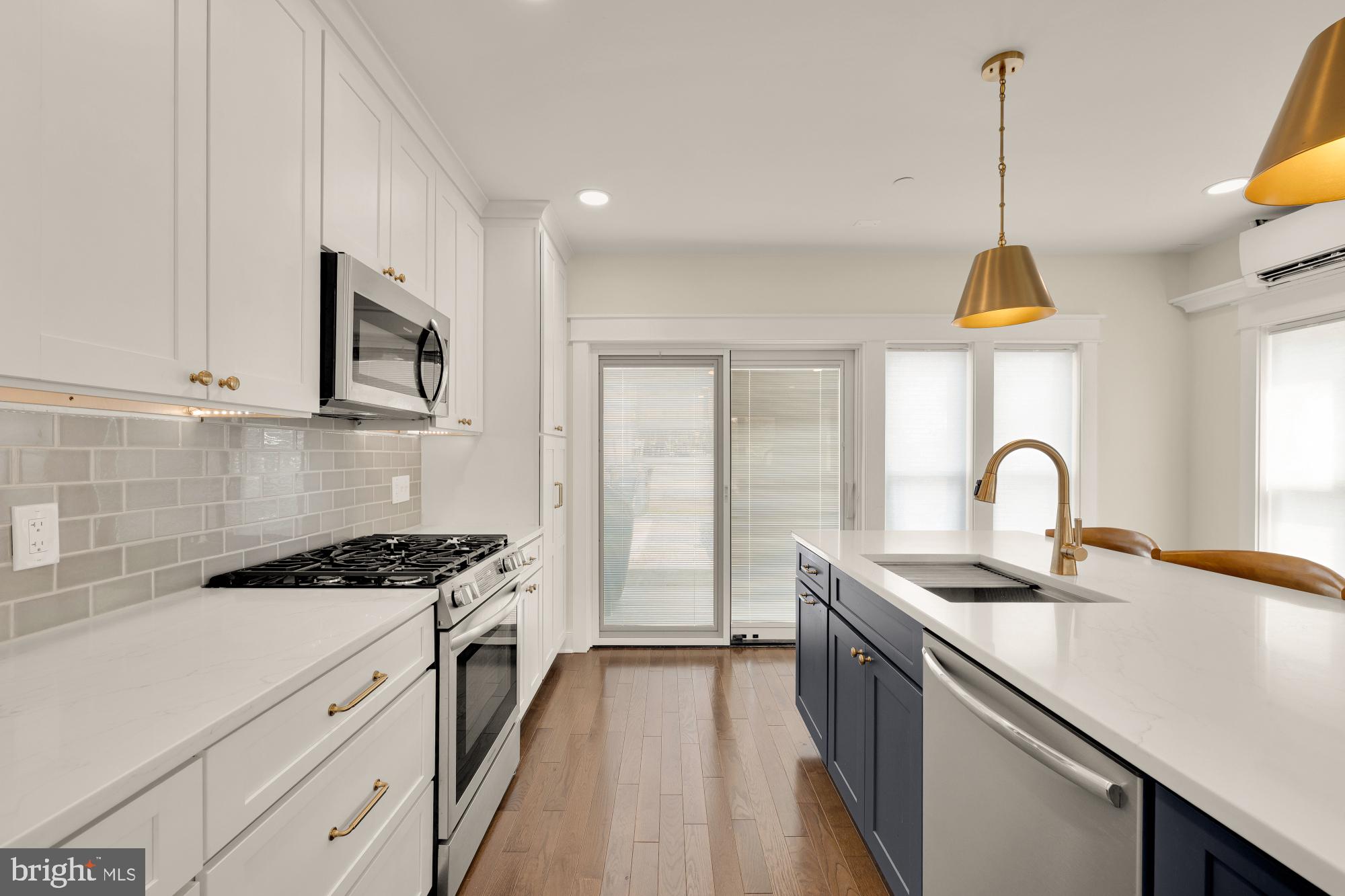 336 Channing Street Northeast, Unit A Washington, DC 20002 - Photo 11 of 28 a kitchen with kitchen island granite countertop a stove a sink a counter space and cabinets