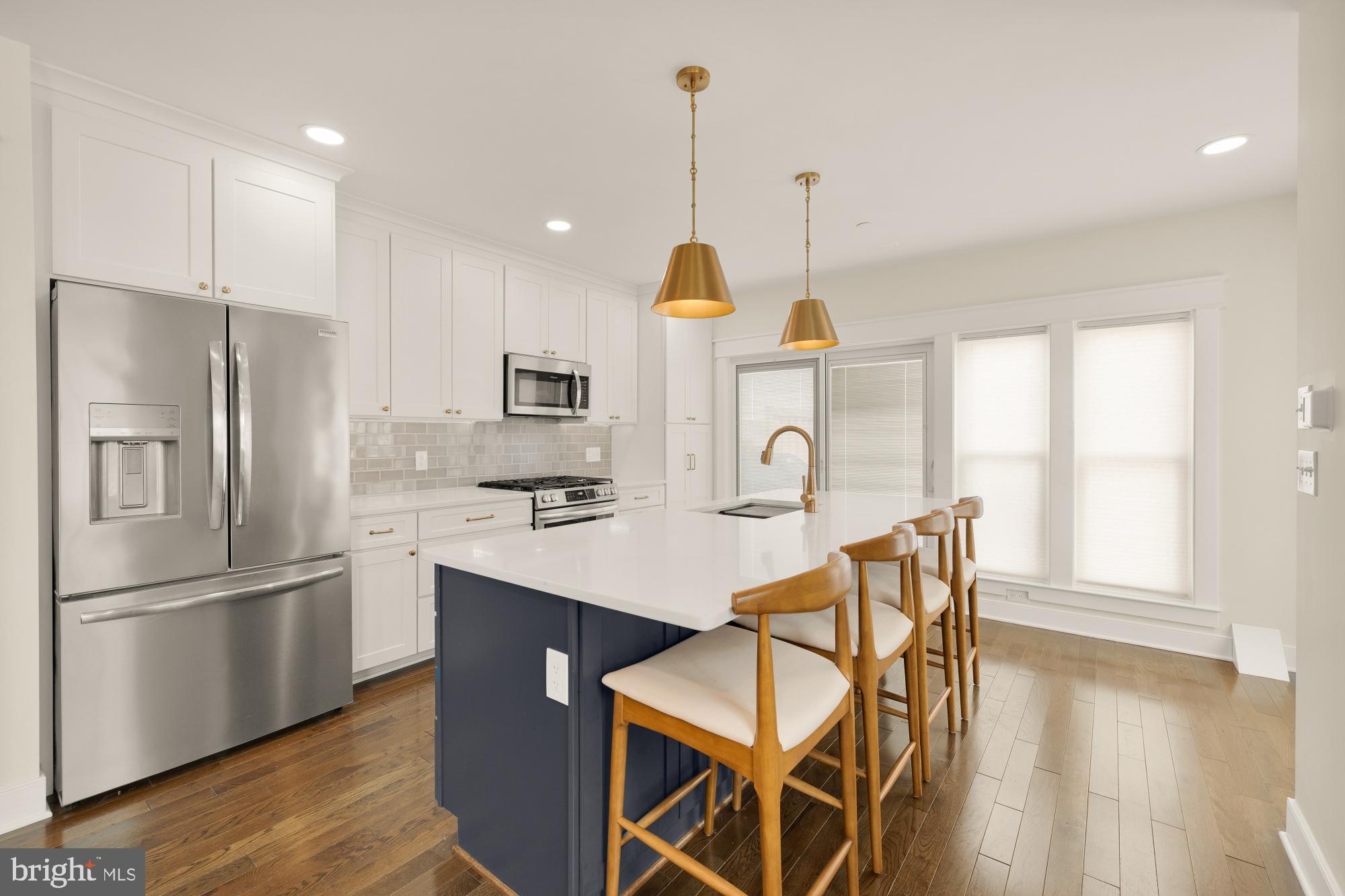 336 Channing Street Northeast, Unit A Washington, DC 20002 - Photo 8 of 28 a kitchen with stainless steel appliances kitchen island granite countertop a refrigerator a stove and a sink with wooden floor