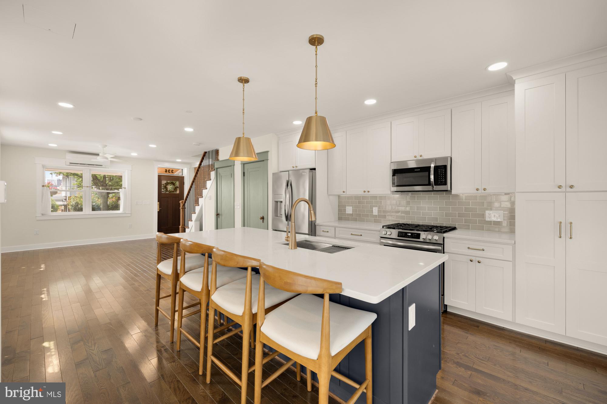 336 Channing Street Northeast, Unit A Washington, DC 20002 - Photo 9 of 28 a kitchen with stainless steel appliances a dining table chairs stove and white cabinets