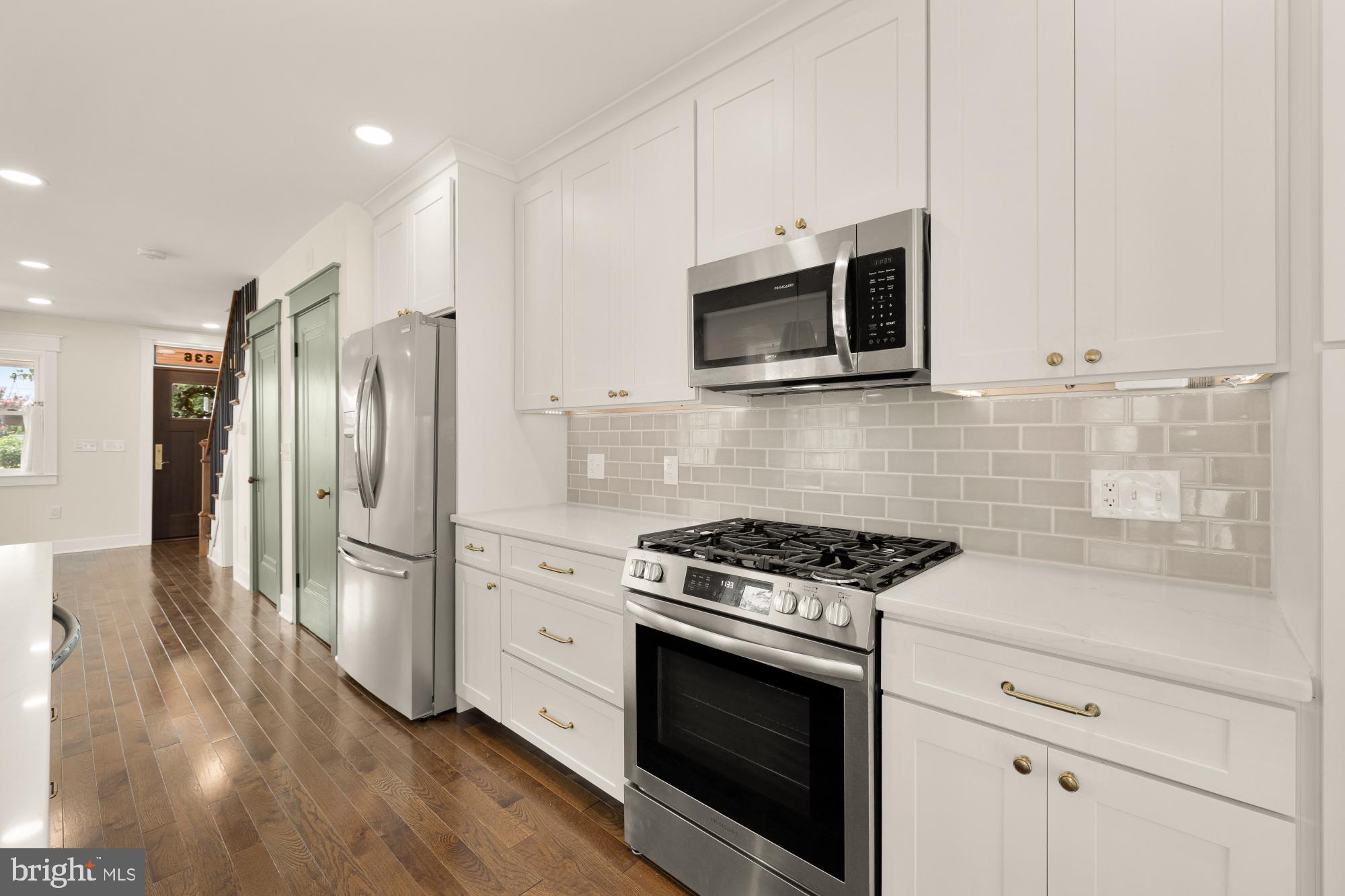 336 Channing Street Northeast, Unit A Washington, DC 20002 - Photo 10 of 28 a kitchen with stainless steel appliances white cabinets a stove a microwave and a refrigerator