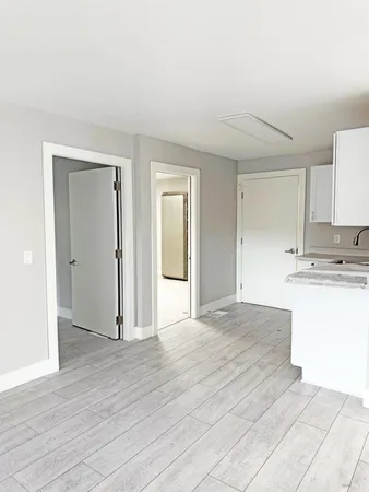 a view of kitchen with granite countertop cabinets and wooden floor
