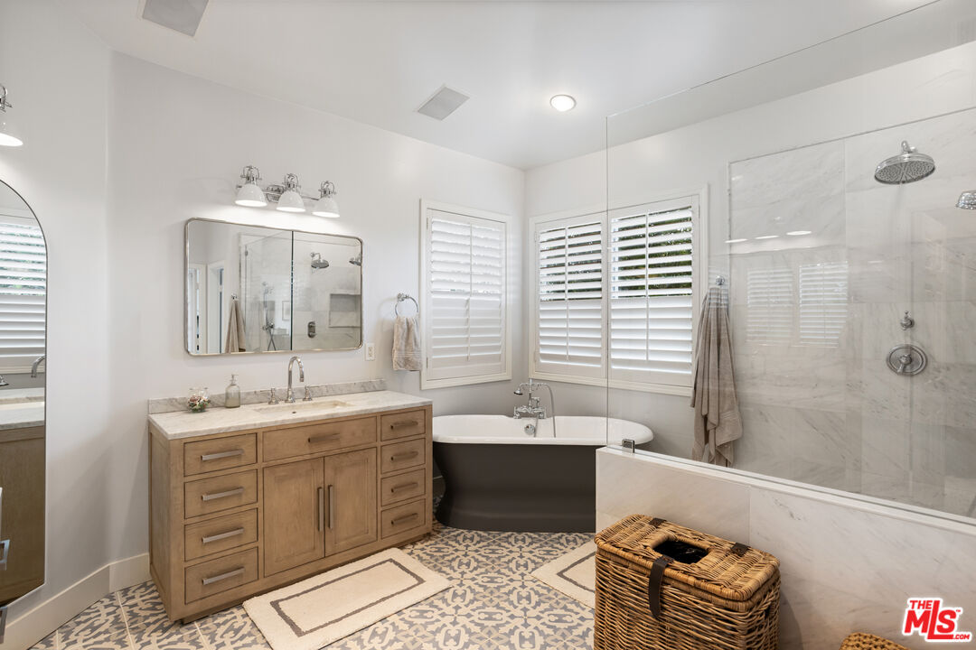 3910 Leighton Point Road Calabasas, CA 91301 - Photo 18 of 29 a bathroom with a double vanity sink large mirror and a bathtub