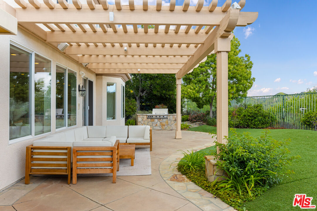 3910 Leighton Point Road Calabasas, CA 91301 - Photo 24 of 29 a view of a patio with a table chairs and a large tree
