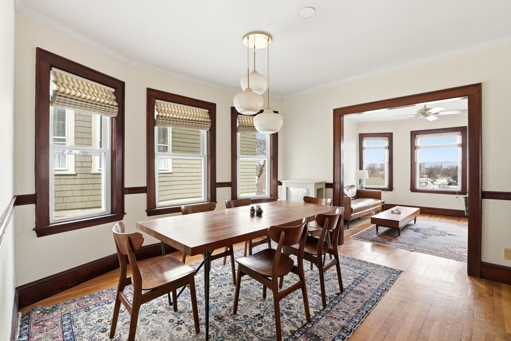 85 Jamaica Street, Unit 3 Boston, MA 02130 - Photo 10 of 19 a dining room with wooden floor a chandelier a wooden table and chairs