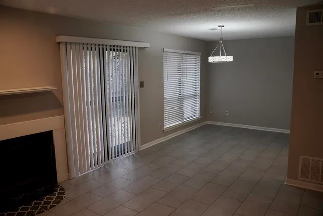 an empty room with staircase and a fireplace