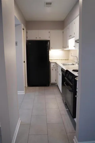 a kitchen with a stove top oven and cabinets