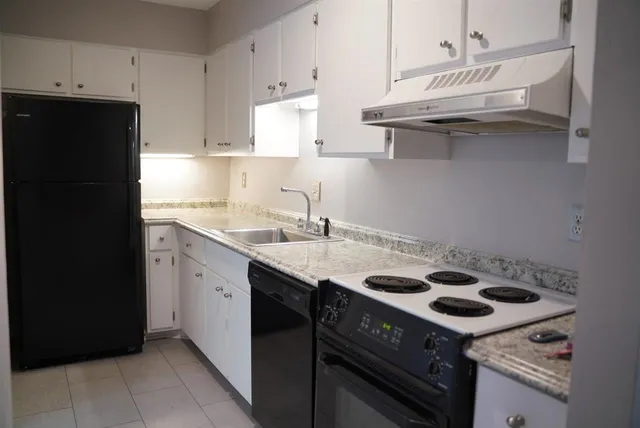 a kitchen with a sink a stove and cabinets