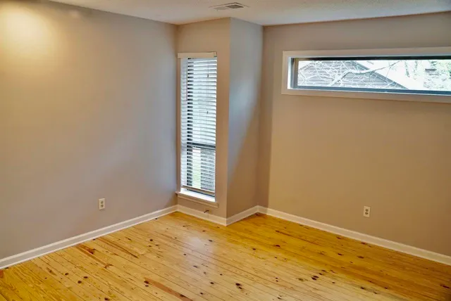 an empty room with wooden floor and a window