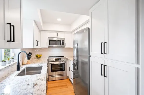 a kitchen with stainless steel appliances granite countertop a refrigerator and a stove top oven