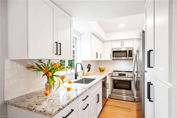 a kitchen with stainless steel appliances a stove a sink cabinets and a counter top space
