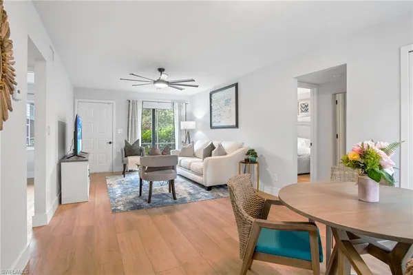 a living room with furniture a window and a potted plant