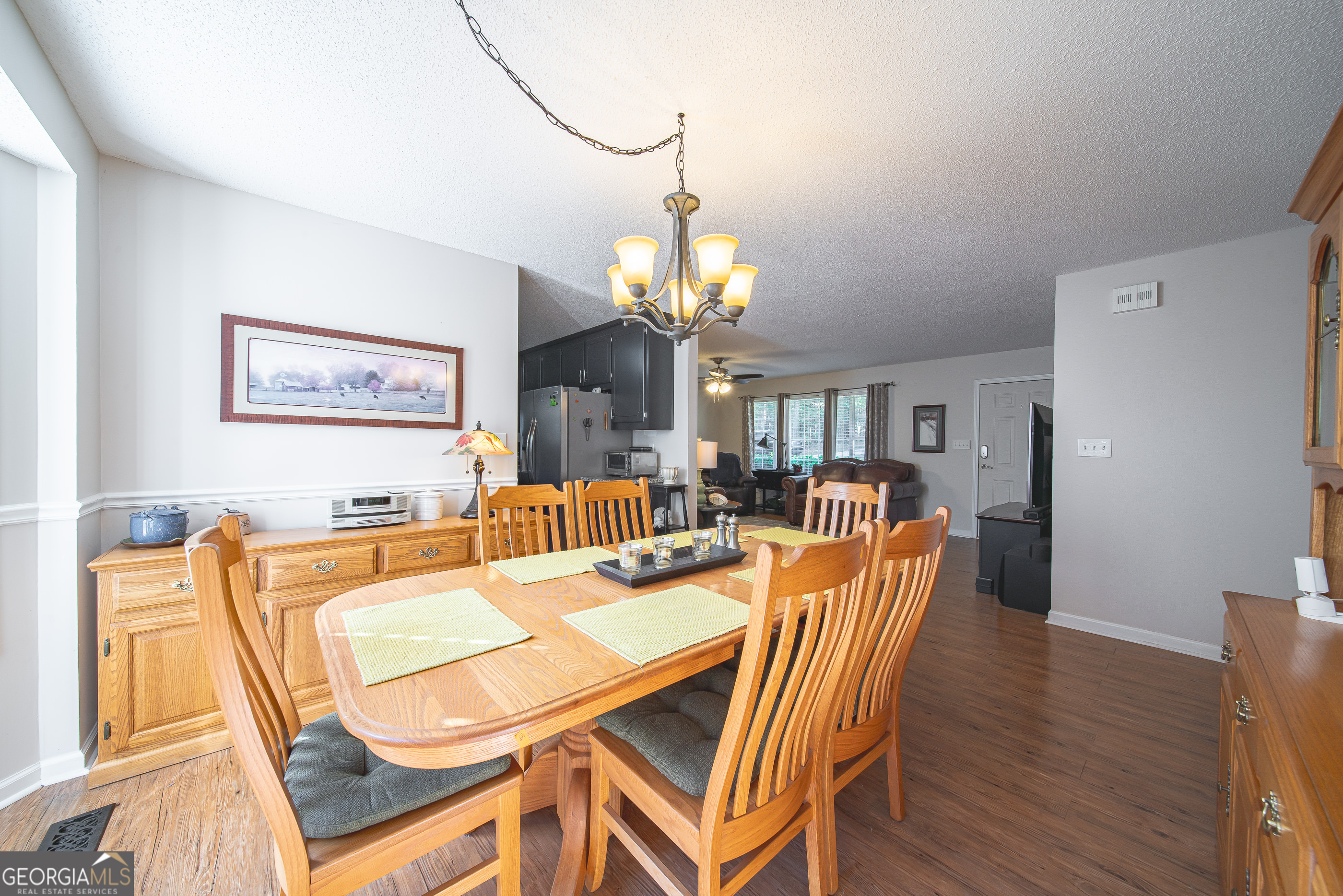 200 Lake Amah Lee Road Hampton, GA 30228 - Photo 14 of 37 a dining room with wooden floor a chandelier a wooden table and chairs