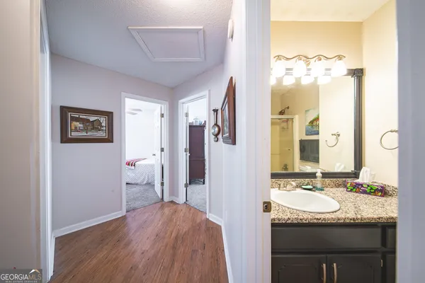 a bathroom with a granite countertop sink a mirror and a bathtub
