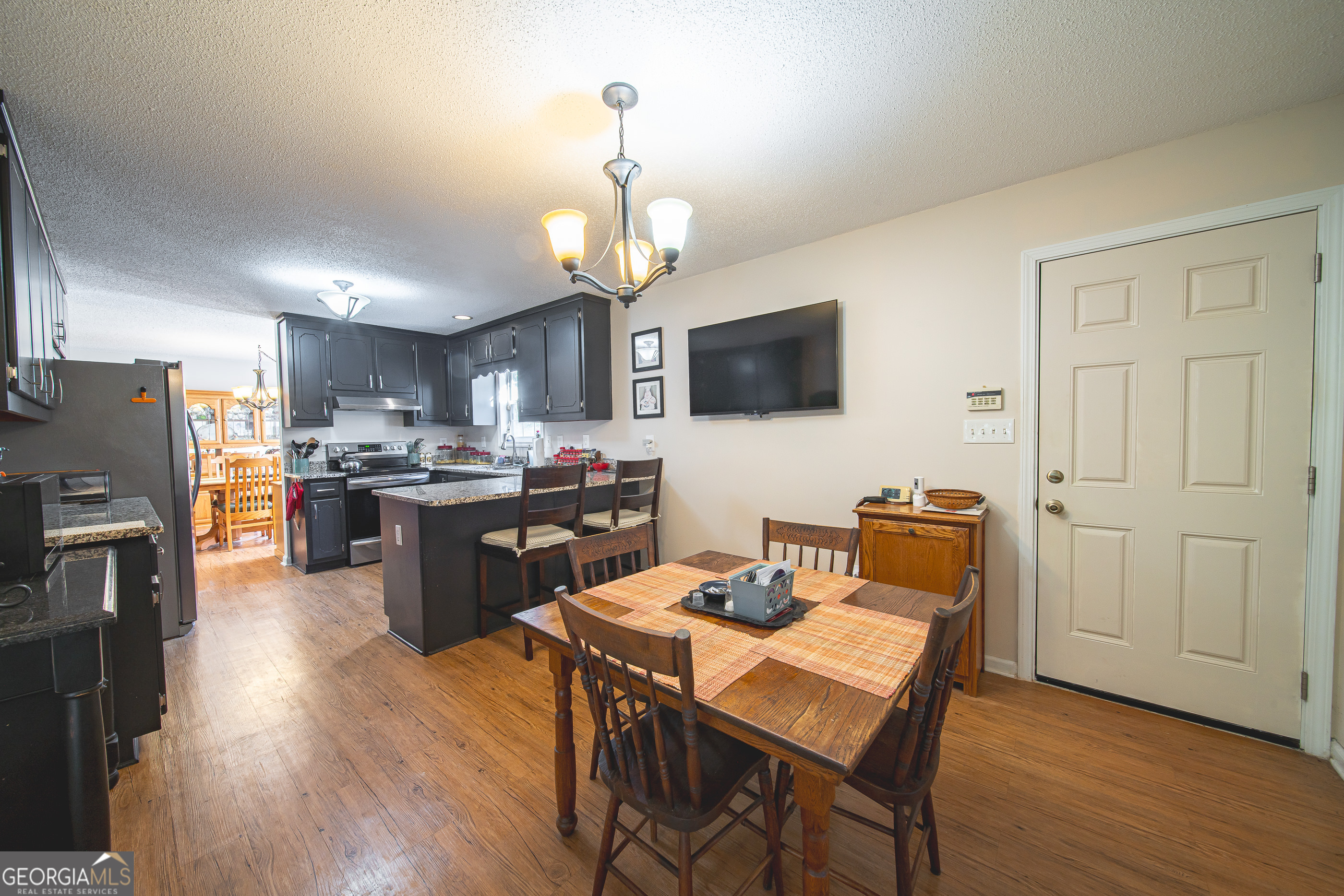 200 Lake Amah Lee Road Hampton, GA 30228 - Photo 19 of 37 a kitchen with a refrigerator a stove top oven a sink dishwasher a dining table and chairs with wooden floor