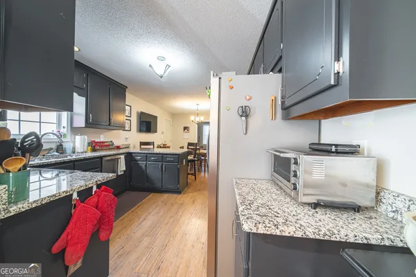 a kitchen with stainless steel appliances granite countertop a refrigerator a stove and a sink
