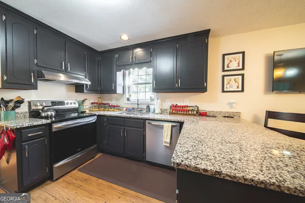 a kitchen with stainless steel appliances granite countertop a sink stove and refrigerator