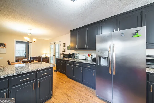 a kitchen with stainless steel appliances granite countertop a sink a stove and refrigerator