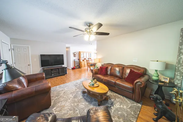 a living room with furniture a flat screen tv and a window