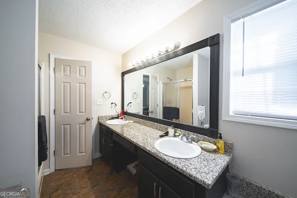 a bathroom with a granite countertop sink and a mirror