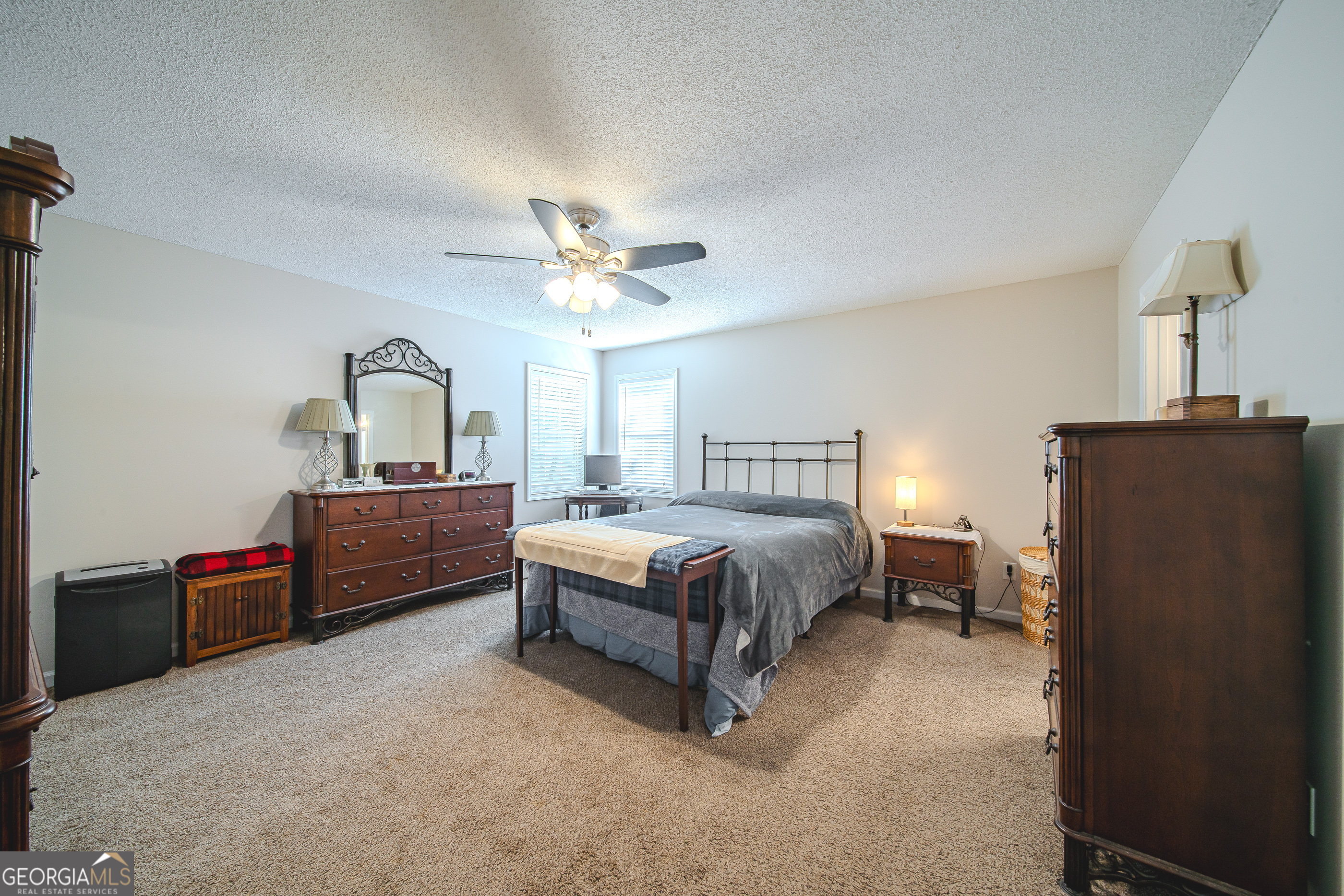 200 Lake Amah Lee Road Hampton, GA 30228 - Photo 32 of 37 a spacious bedroom with a bed and a chandelier