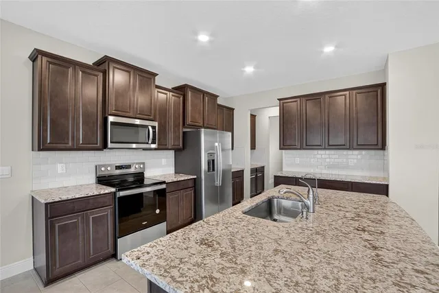 a bathroom with a granite countertop sink toilet and mirror
