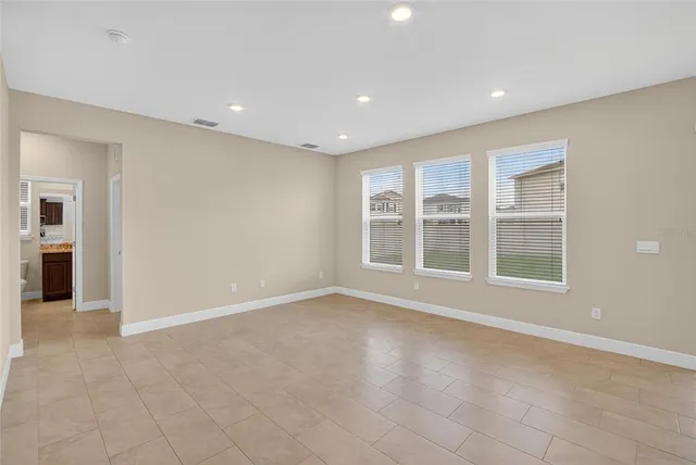 a view of an empty room with closet and a window