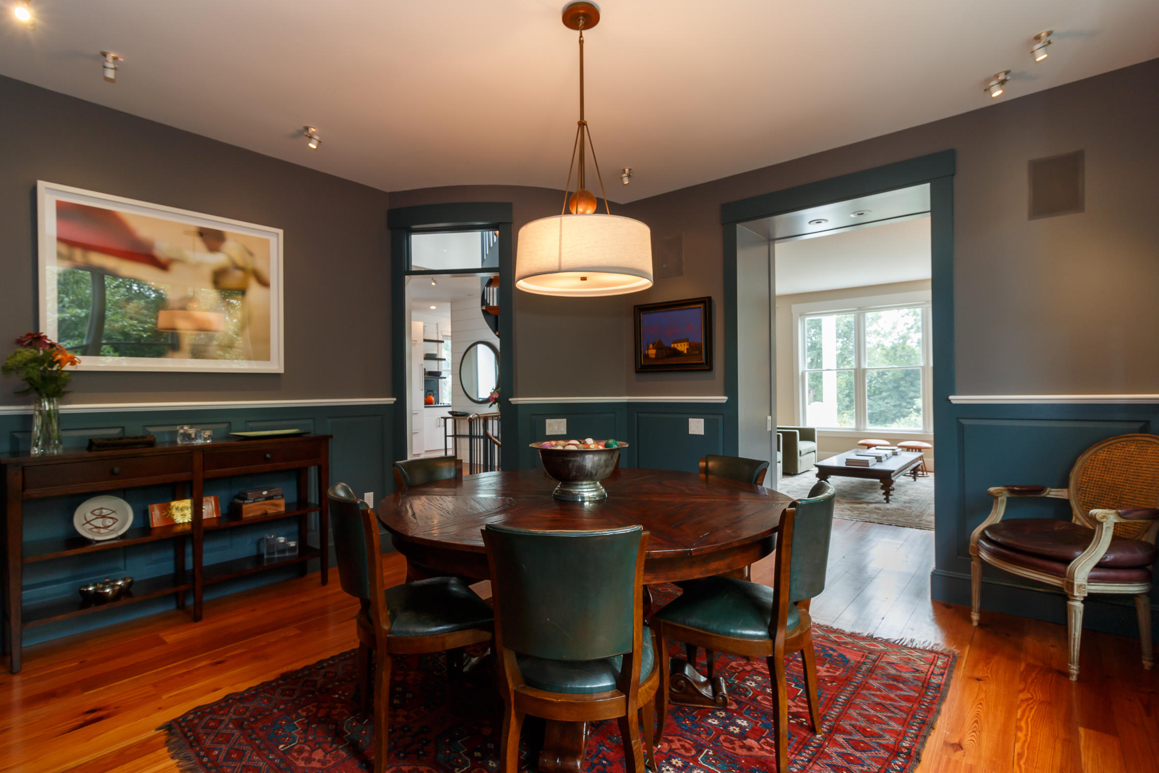 52 Point Street Provincetown, MA 02657 - Photo 12 of 35 a dining room with furniture wooden floor a rug a fireplace and a chandelier