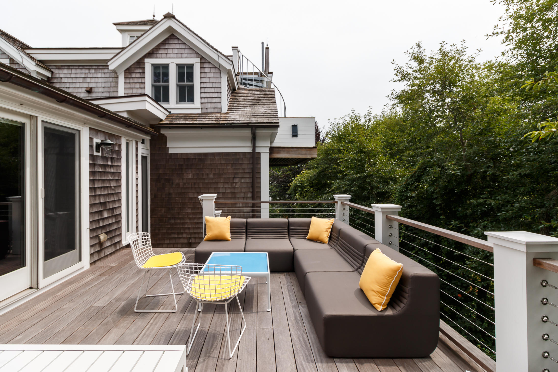52 Point Street Provincetown, MA 02657 - Photo 8 of 35 a view of a deck with couches table and chairs with wooden floor and fence