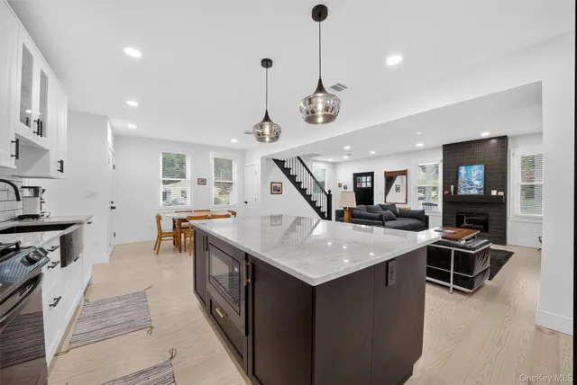 a open kitchen with stainless steel appliances granite countertop a stove and living room view