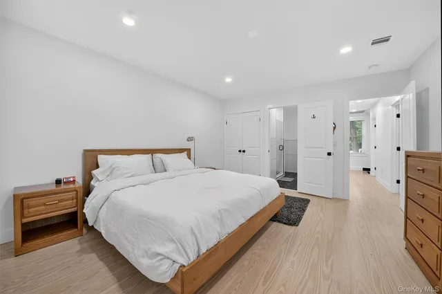 a spacious bedroom with a bed and a wooden floor