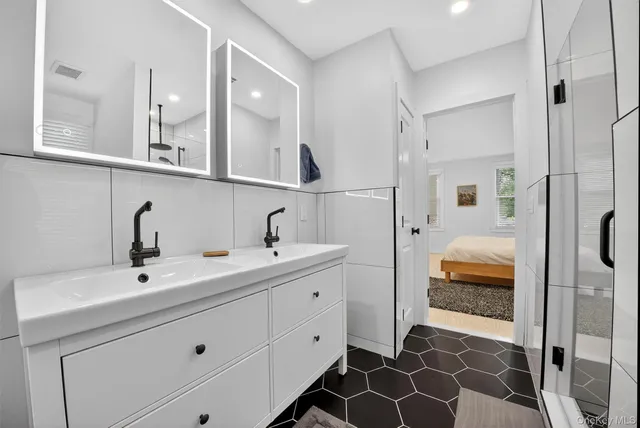 a en suite bathroom with a double vanity sink a mirror and shower