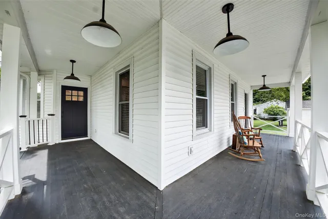 a view of a hallway with furniture and a window