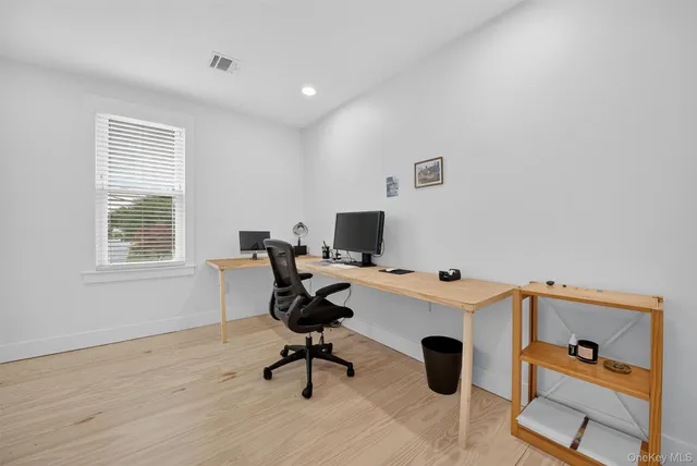 a view of a workspace with furniture and a window
